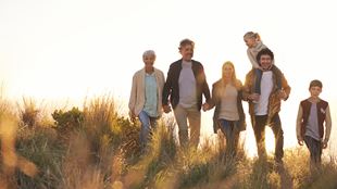 family walking in grassy field