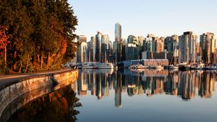 Vancouver skyline reflecting in the water in Stanley Park at sunset