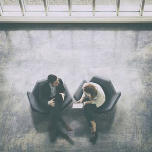 Two people talking in chairs.