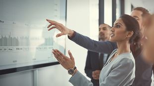 Groupe de personnes regardant et pointant à l'affichage grand dans la Conférence