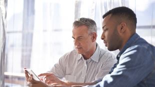 two men working on mobile device