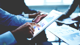 Three men looking at financial charts