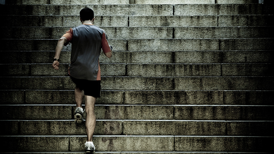 Un homme en vêtement de sport monte des escaliers.